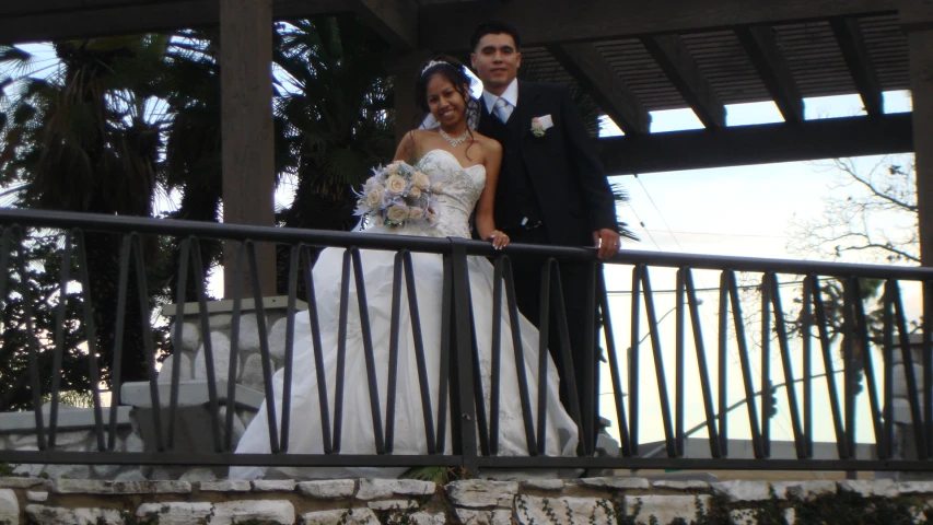 a newly married couple standing on the balcony