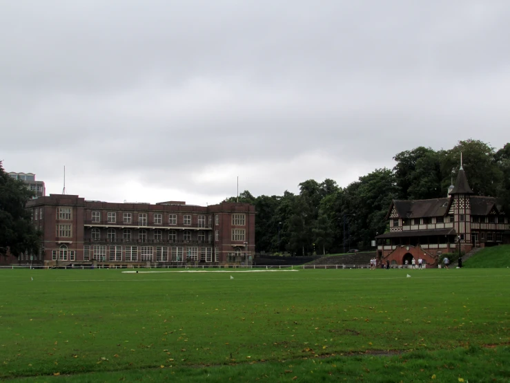 an old building in the background next to a lush green field