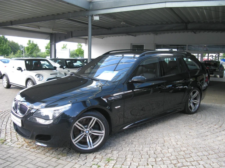 a black bmw is parked in front of a building