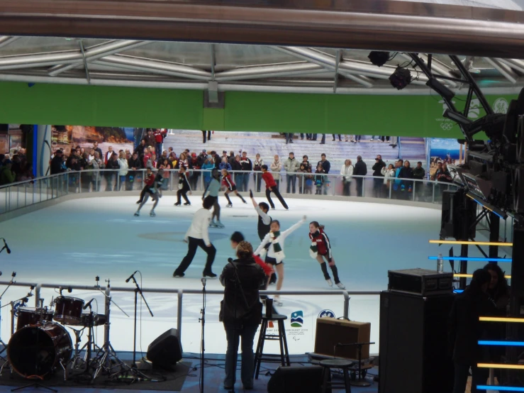 an ice skating rink with people standing around