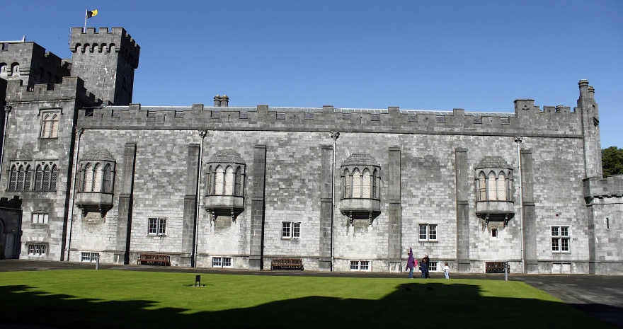 a person standing outside of a large castle like building