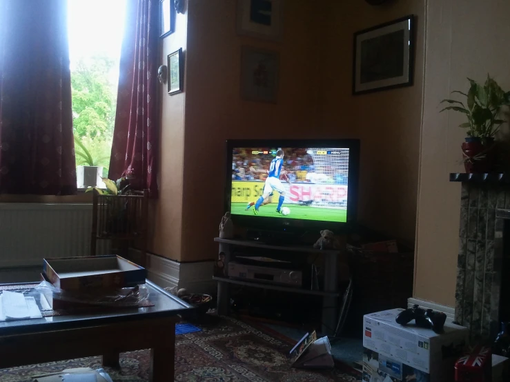 a television set in a living room with a football game