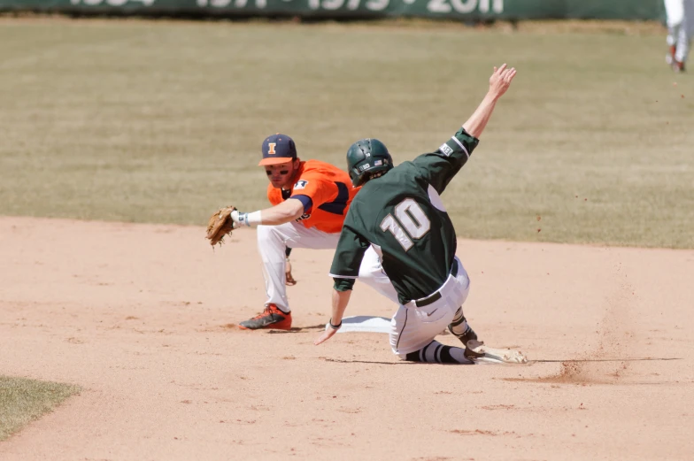 two baseball players going after the ball, one falling