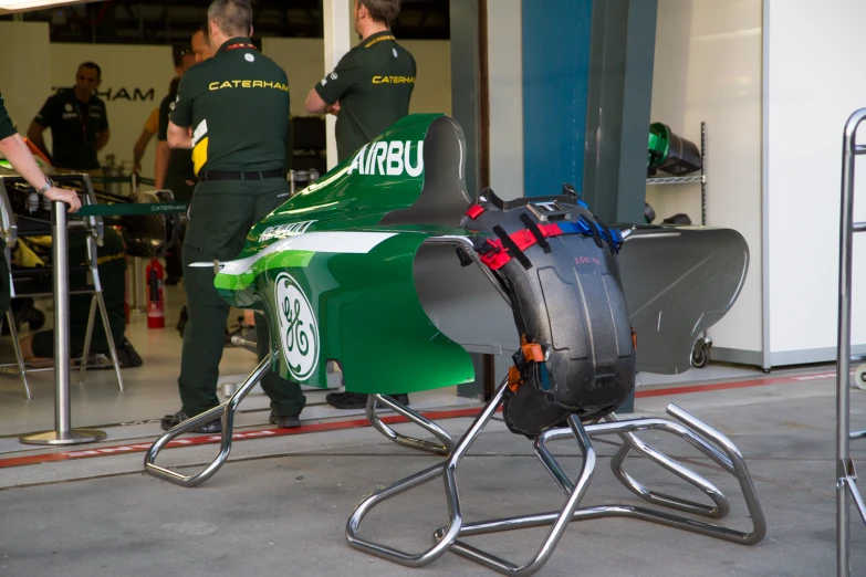 a racing car being prepared by men in uniforms