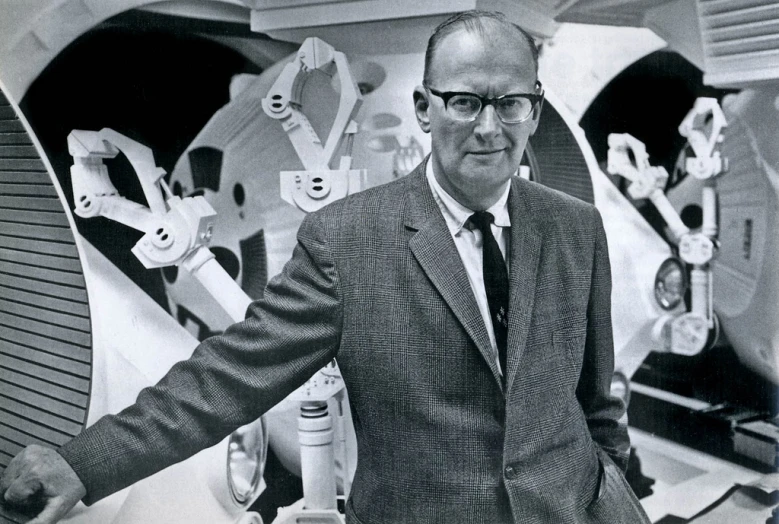 a black and white image of a man in a suit standing near some skis