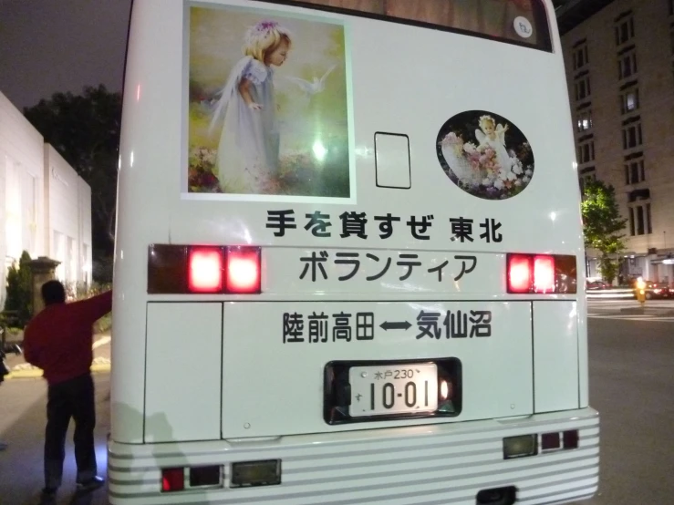 an asian white bus with lots of writing on it