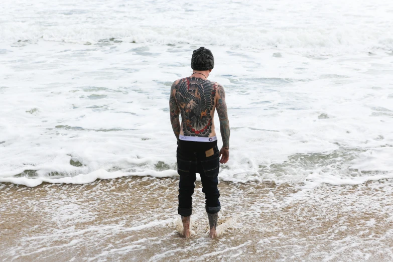 an individual standing in the ocean and looking out