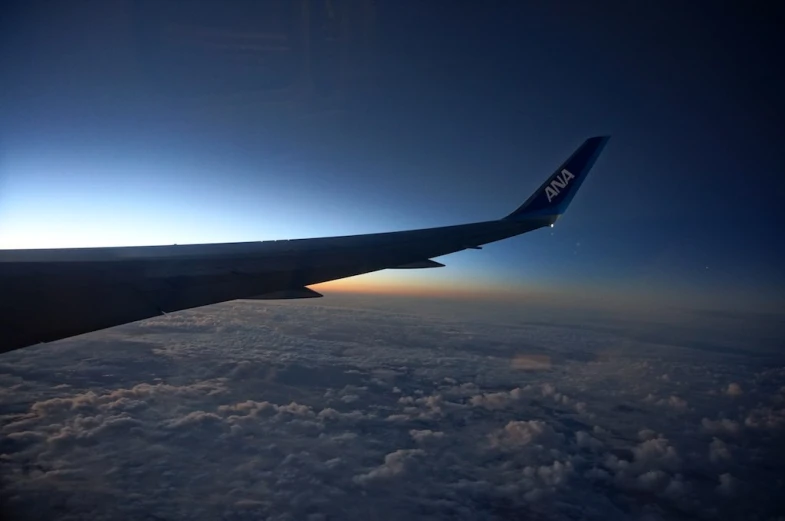 the wing of an airplane that is flying high in the sky