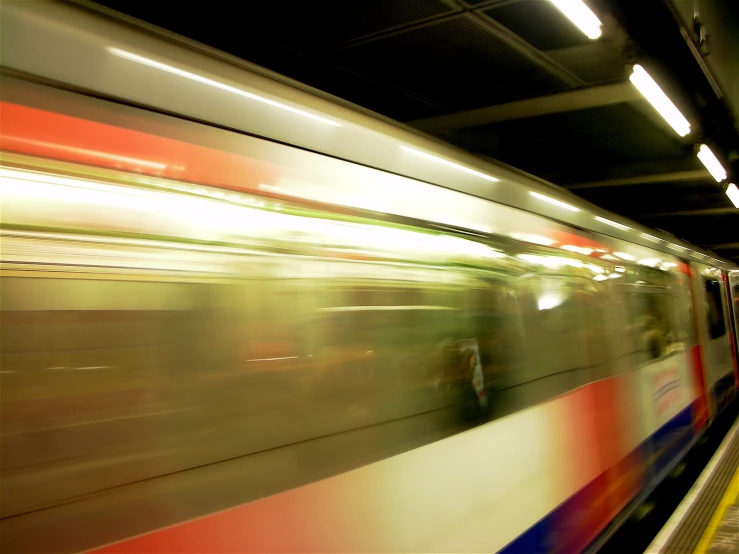 a blurry image of a train traveling through a subway station