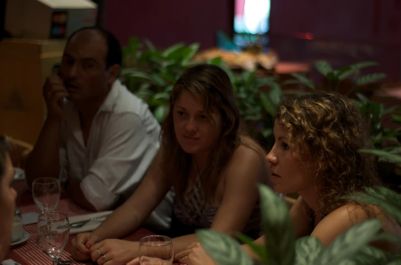 some people sitting around a table drinking wine