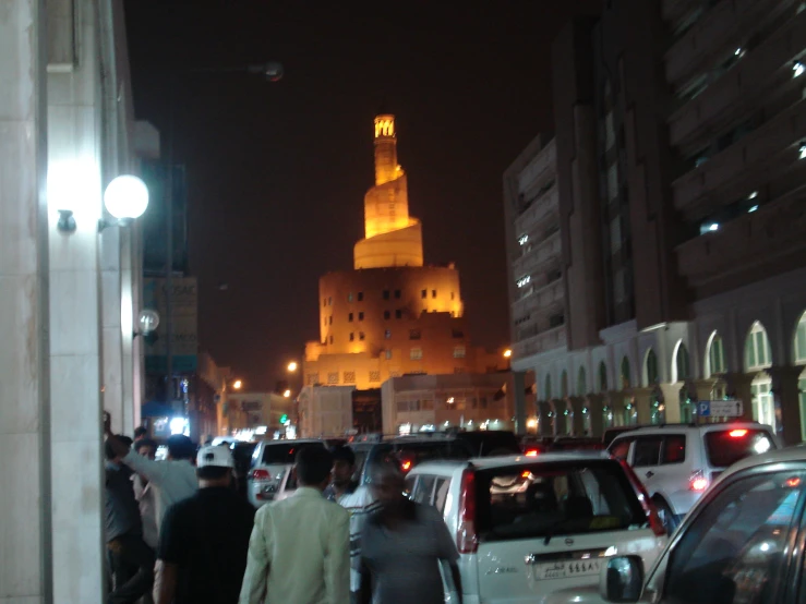 a very crowded street with people standing and walking by