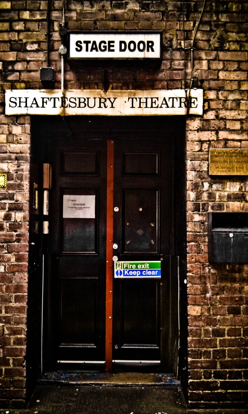 a brick building with black doors and street signs on it