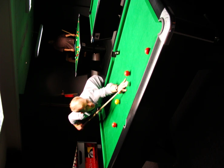 a little  is playing with a billiard