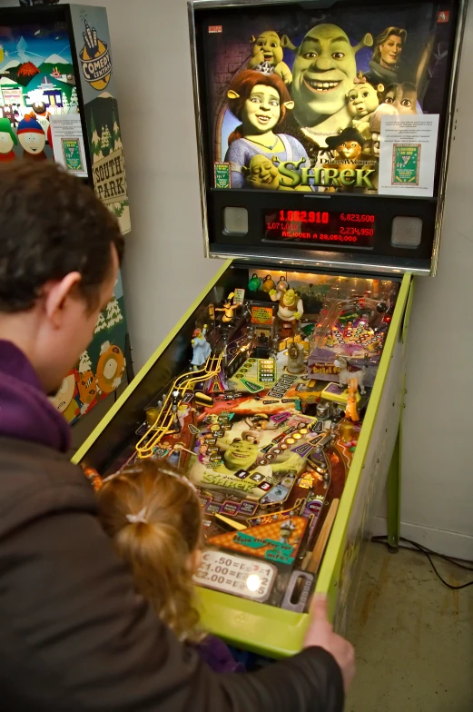 an adult plays with an arcade machine with cartoons