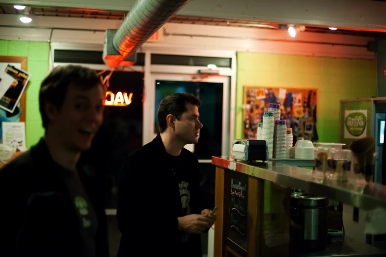 two men walking past the counter at a restaurant