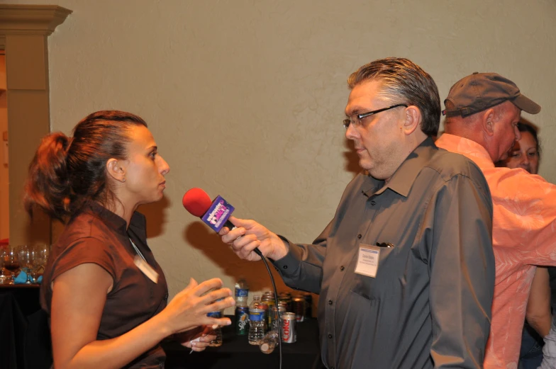 a woman in a grey shirt standing next to a man on the phone