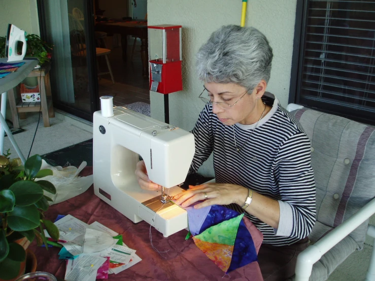 a woman uses a sewing machine to sew on a table