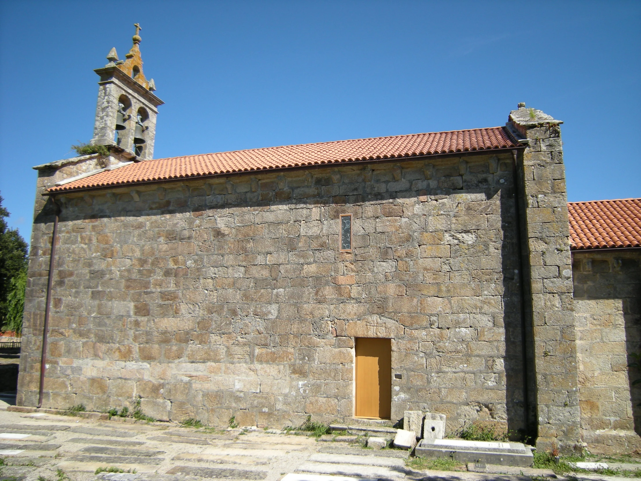 a small brick building with a tall tower behind it