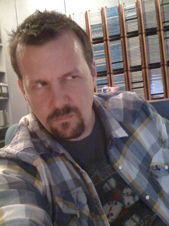 a man in plaid shirt with beard and glasses