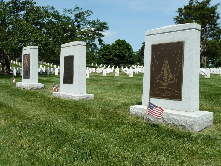 a memorial sits in a graveyard with two flags