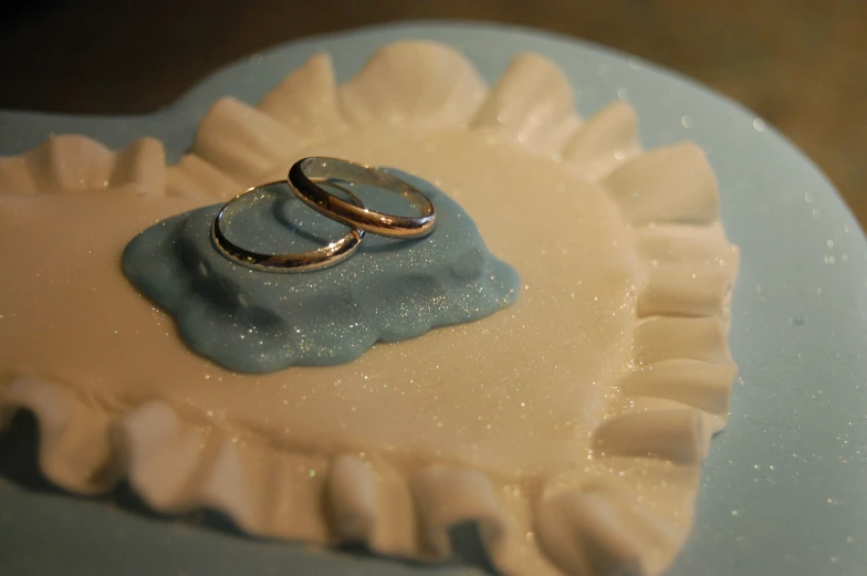 a ring is displayed in the middle of a white and blue cake