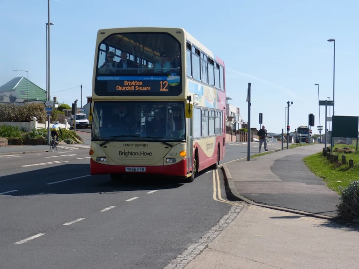 a double decker bus driving down a street with a sign on it