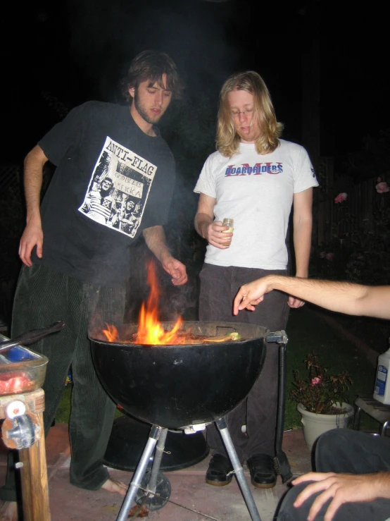 a man and woman looking down at a fire