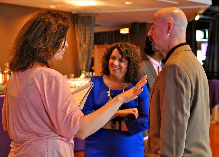 woman having a conversation with three others at a social event