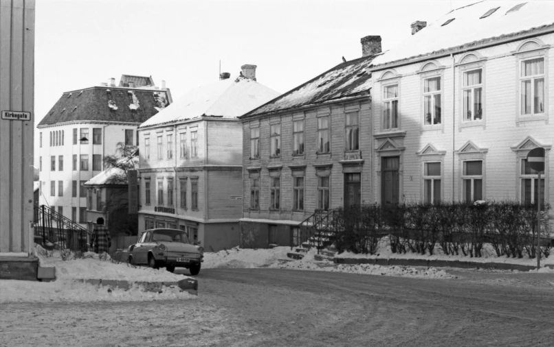 a truck parked in front of several tall buildings in the snow