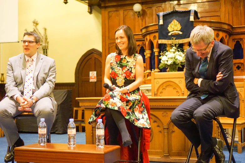 two men and a woman sitting in front of some bottles