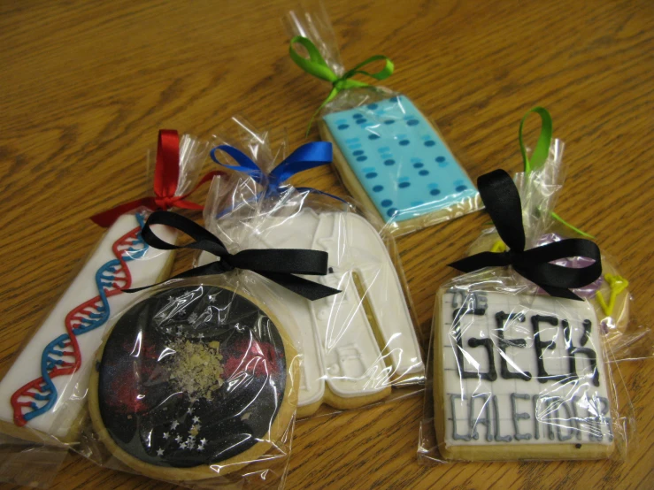 three cookies on a table, some are decorated with the logos of several nds