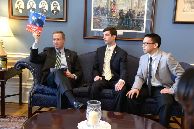 four businessmen talking and discussing while sitting in a room