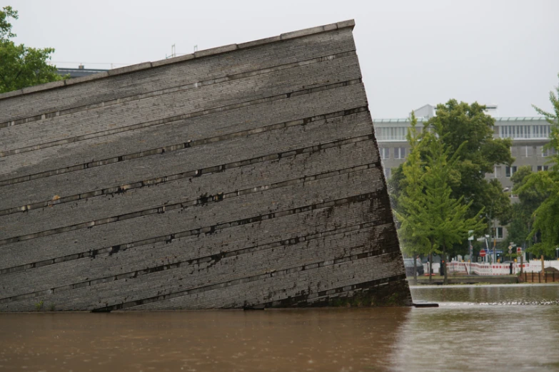 the side of an old wooden structure with some trees in it