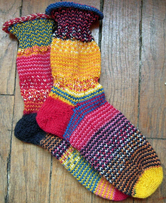 an unmade crocheted pair of socks on the floor