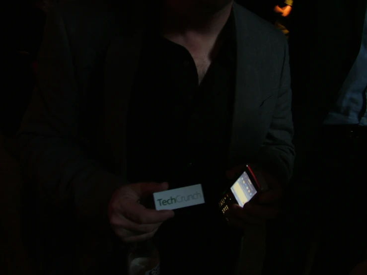 a man holding his phone in the dark