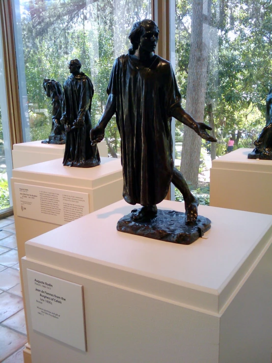 several bronze statues in front of an open window