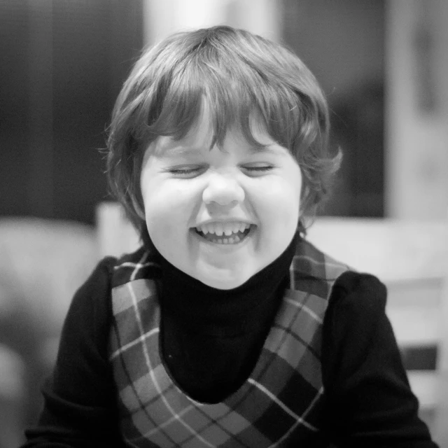 a little girl laughing in black and white