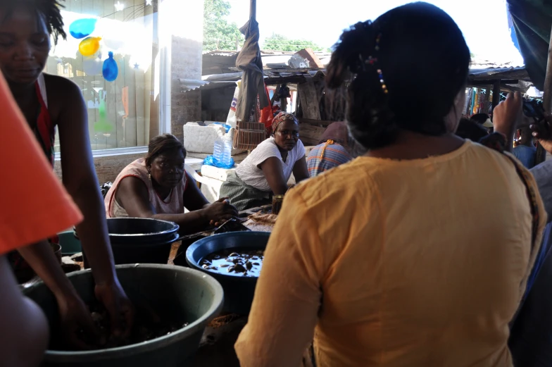 several people are sitting around and working on some food