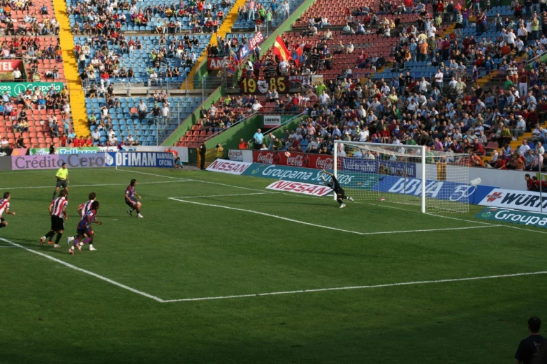 people playing soccer in a stadium with fans