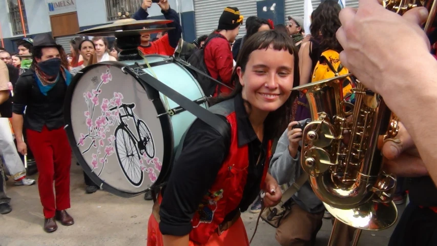 a girl wearing red with a marching outfit on and some musicians