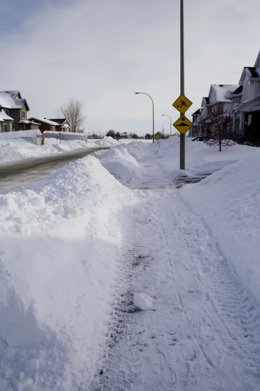 a sign sitting next to snow covered roads on a city street