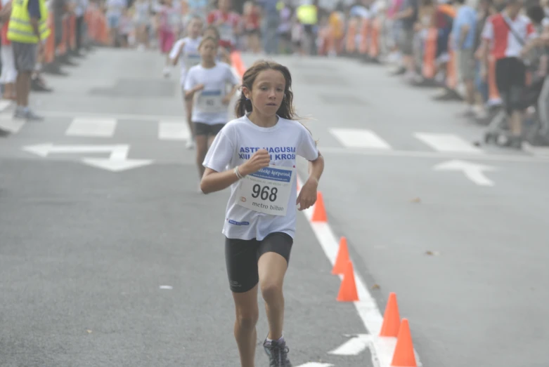 a  running through an orange cone trail in the street