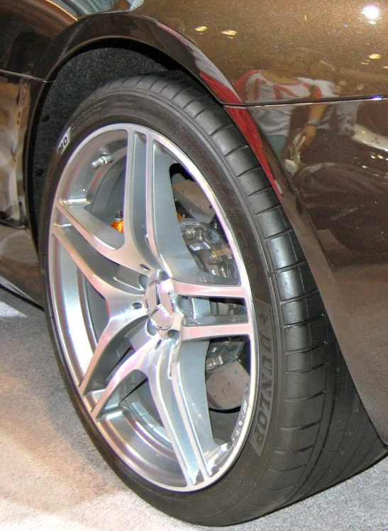 car tire with chrome rim and spokes in showroom