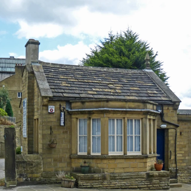 a small house with a blue door is seen in the middle of a road