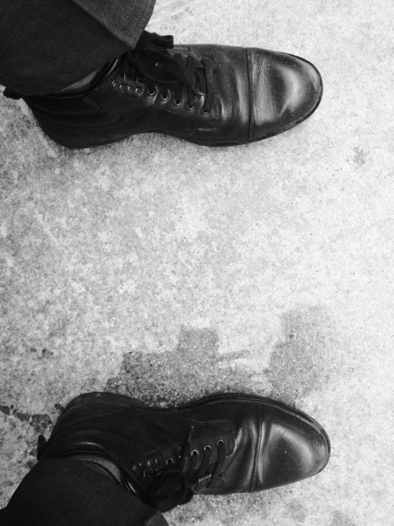 the legs and shoes of men in business wear are lined up against a concrete surface