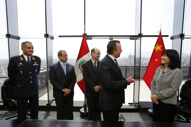 three people are talking next to some flags