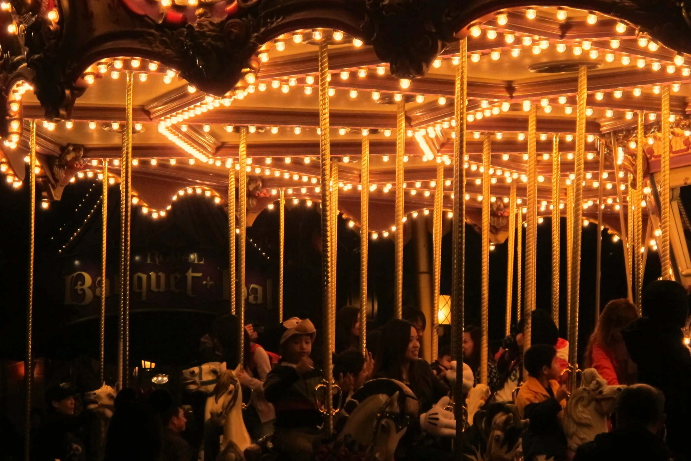 people are sitting on the carousel during the night