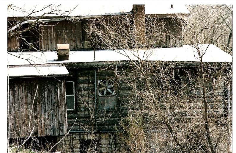 an old building with broken windows in the snow