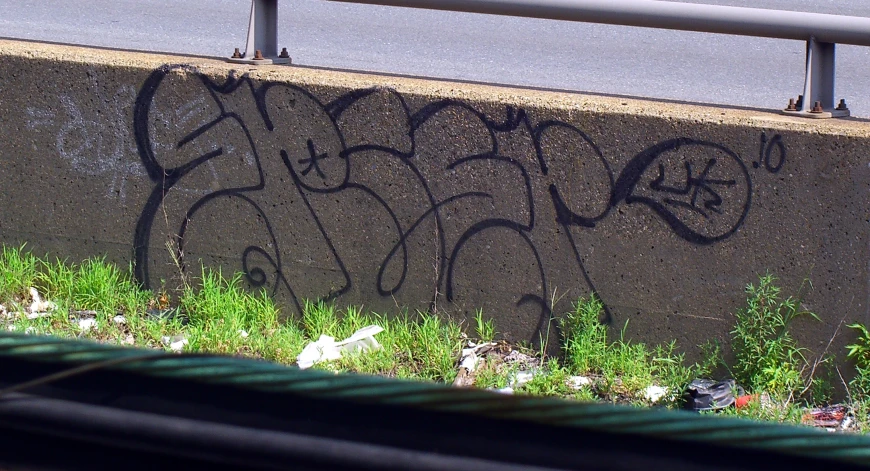 graffiti on the side of a road near traffic lights