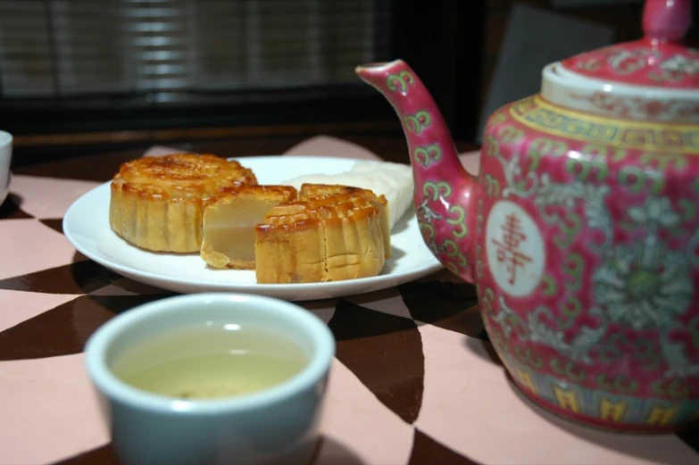 the plate is next to tea with cakes